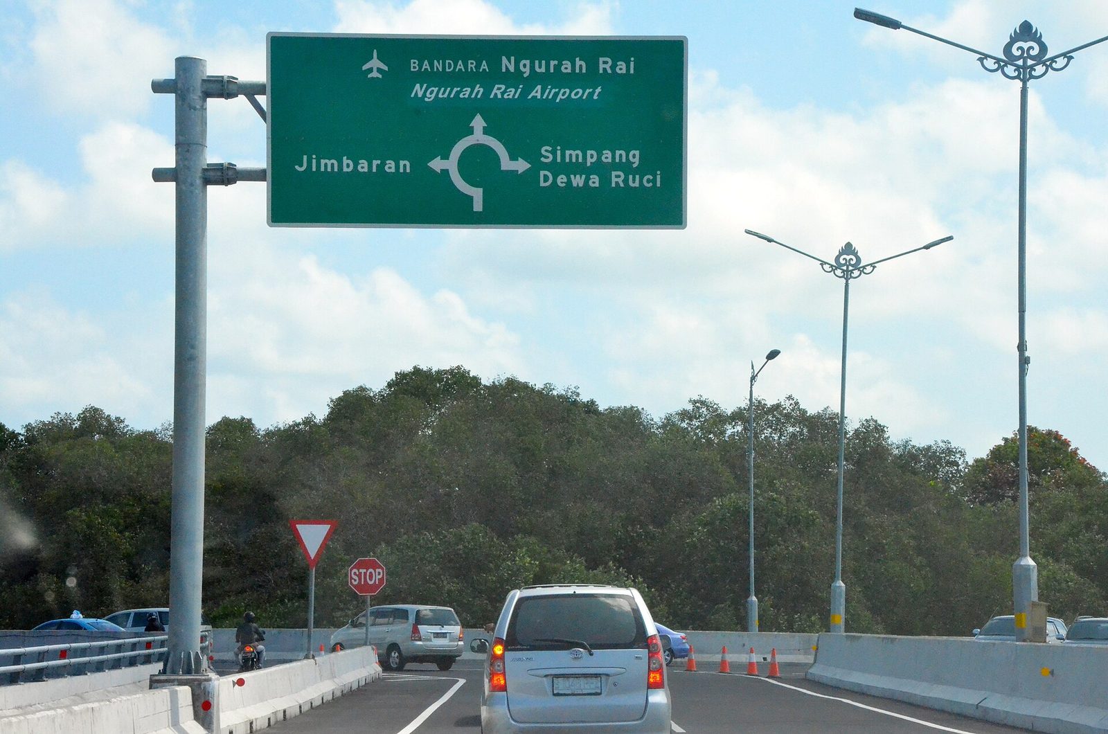 Green road sign pointing to Ngurah Rai Airport, Jimbaran and Simpang Dewa Ruci