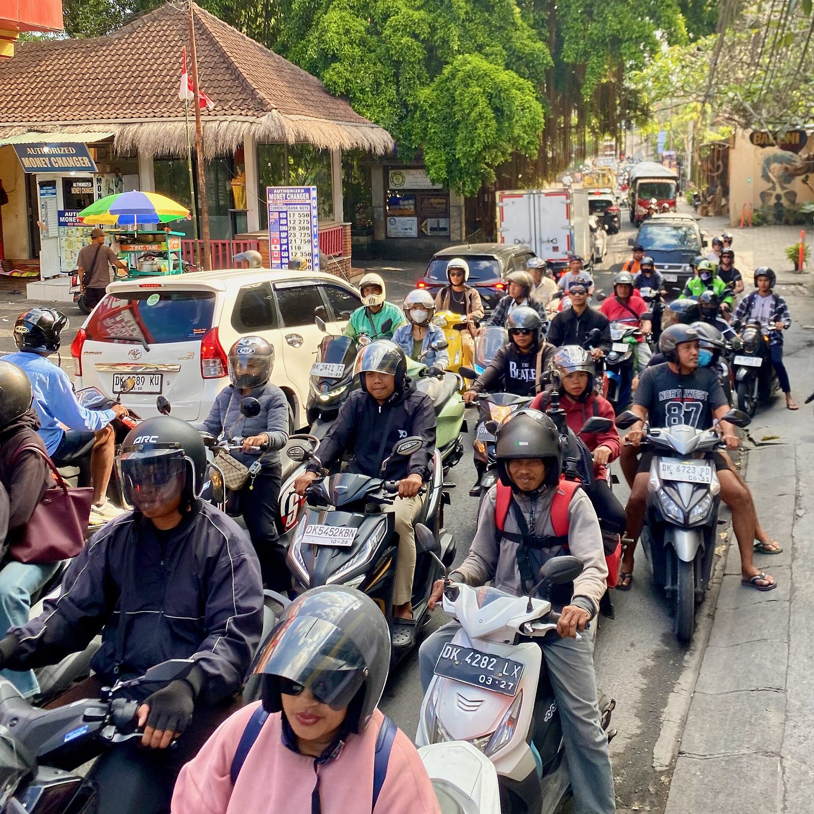 Riders on scooters queuing in afternoon traffic in Ubud