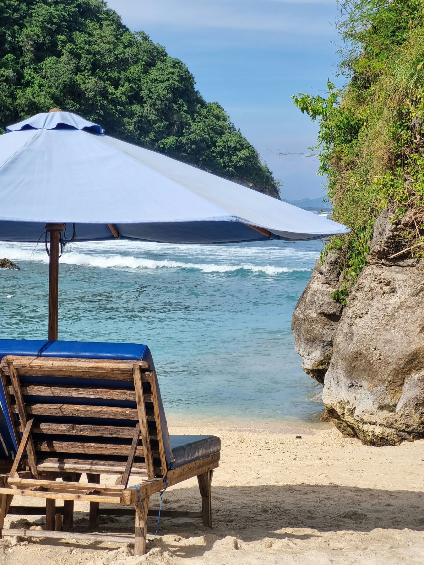 Umbrella and lounge chairs overlooking Atuh Beach