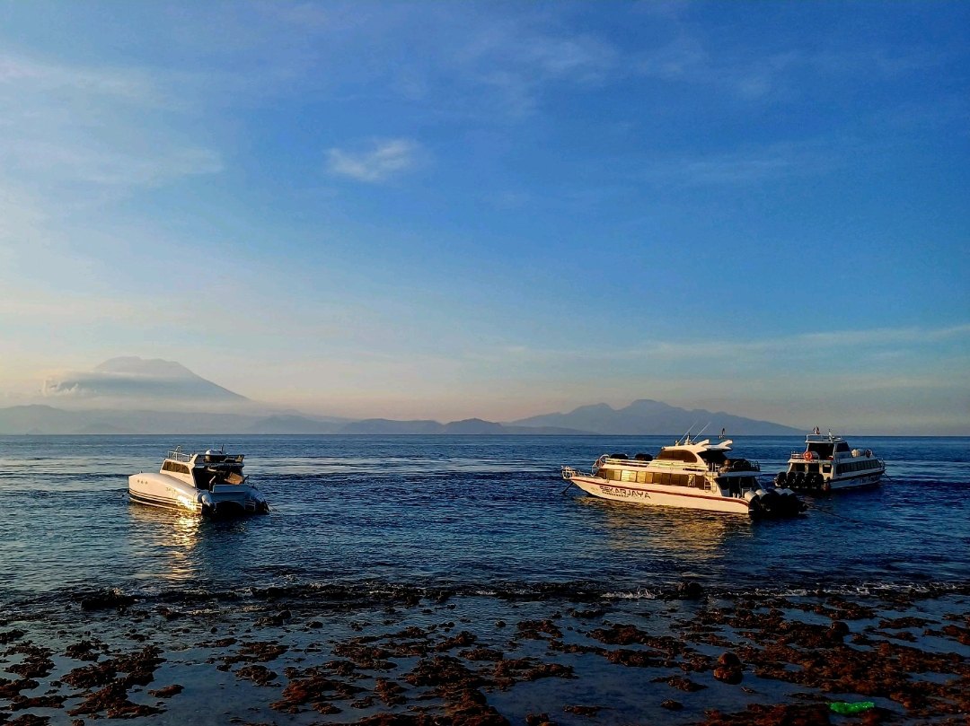 Boats off Kutampi Beach with Mount Agung across the strait