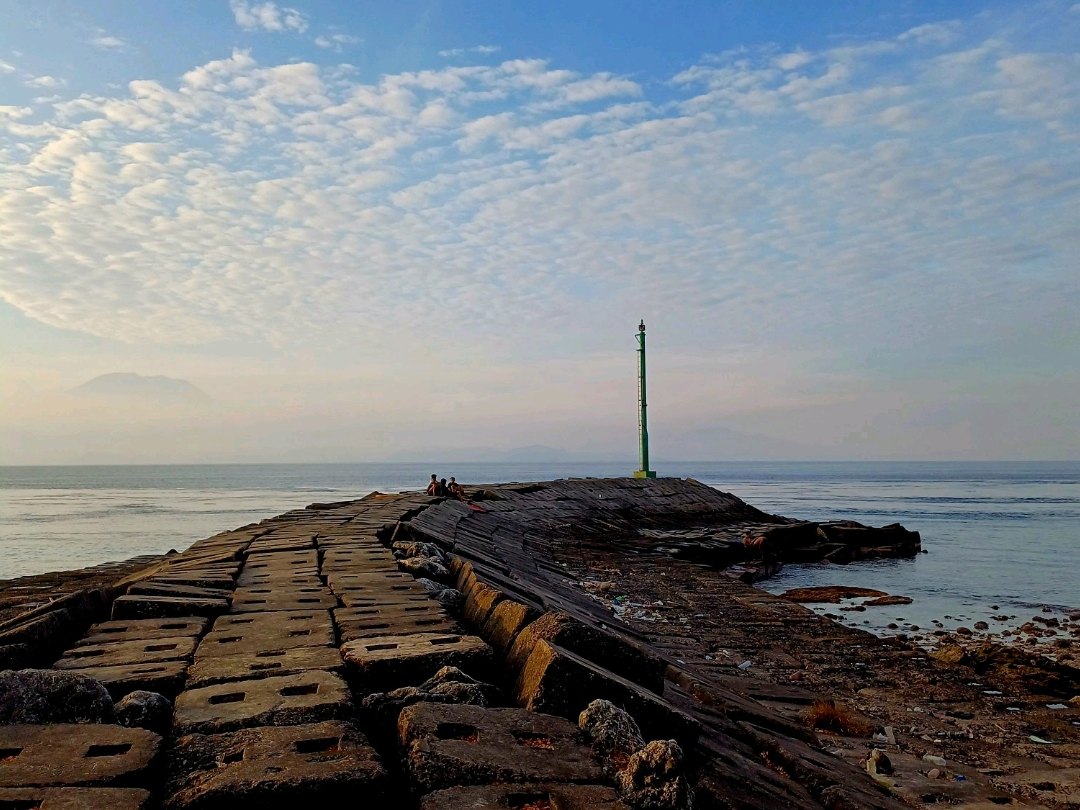 Stone breakwater extending into the sea at Kutampi