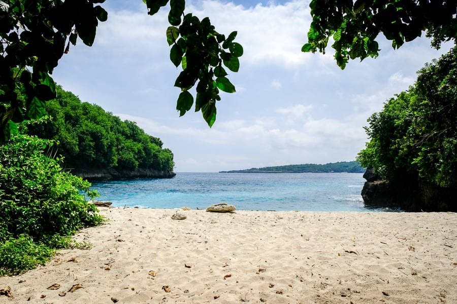 Sand and trees at Puyung Beach with a wooded headland across the water