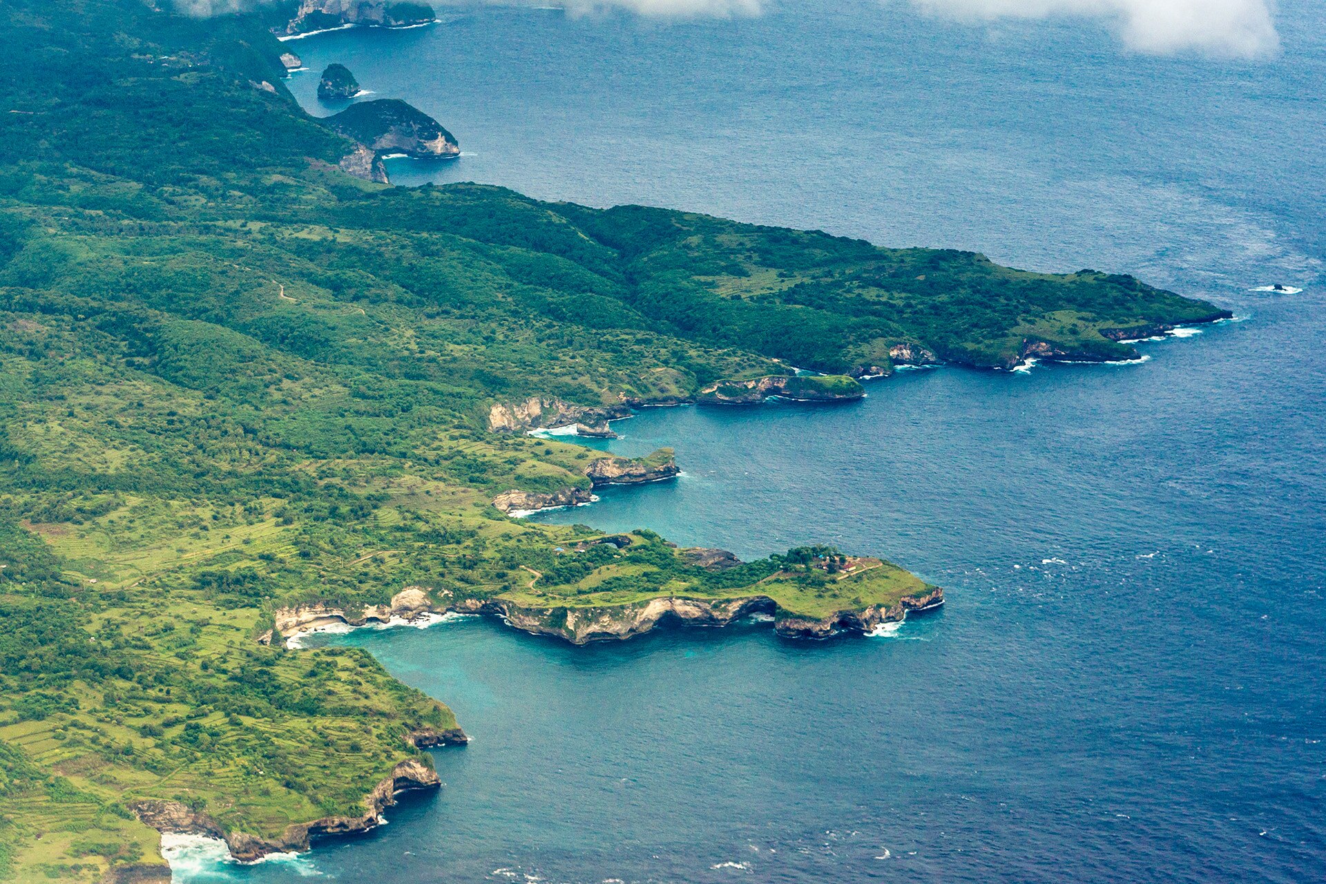 Aerial view of the green, cove-lined west coast of Nusa Penida