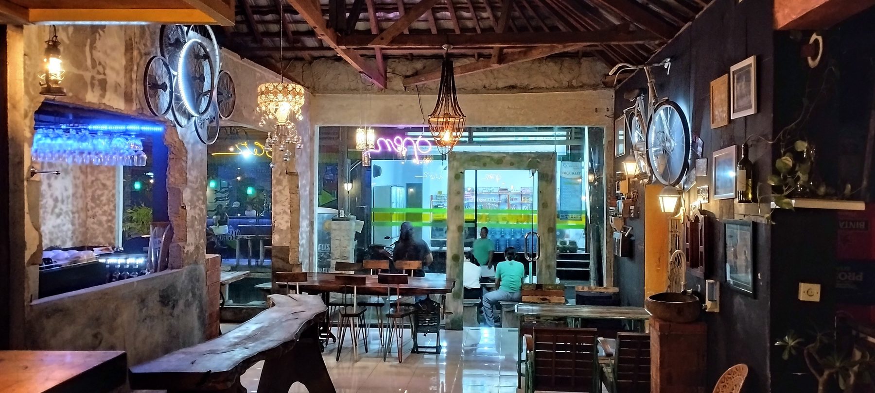 Vintage-style dining room at Artrolling Bistro with wooden tables, wall clocks and a chandelier