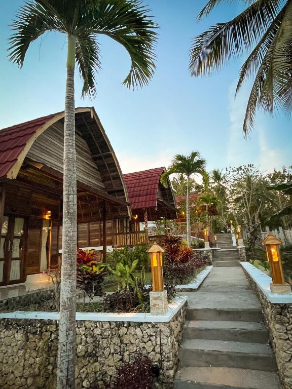 Wooden guest bungalows and a lantern-lined garden path at Griyatama Bungalow in Nusa Penida