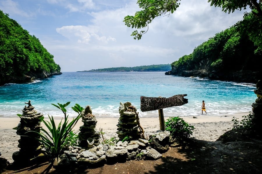 Pandan Beach cove and beach sign beyond Crystal Bay in Nusa Penida