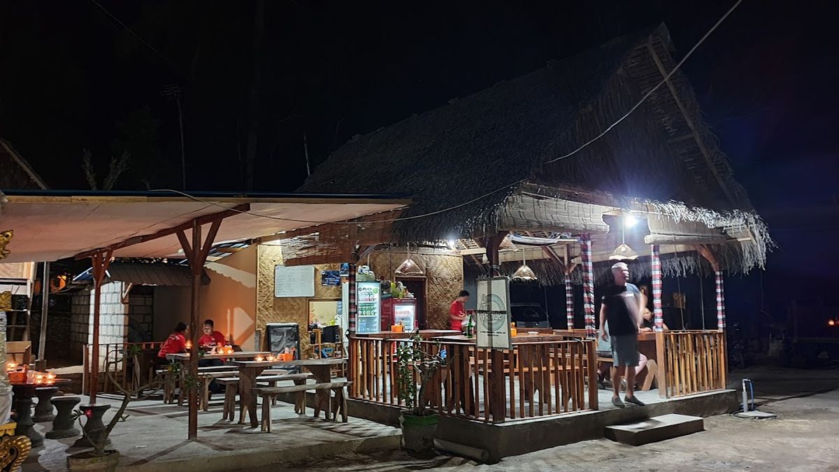 Zone de restauration en plein air à Warung Tu Pande à Nusa Penida le soir
